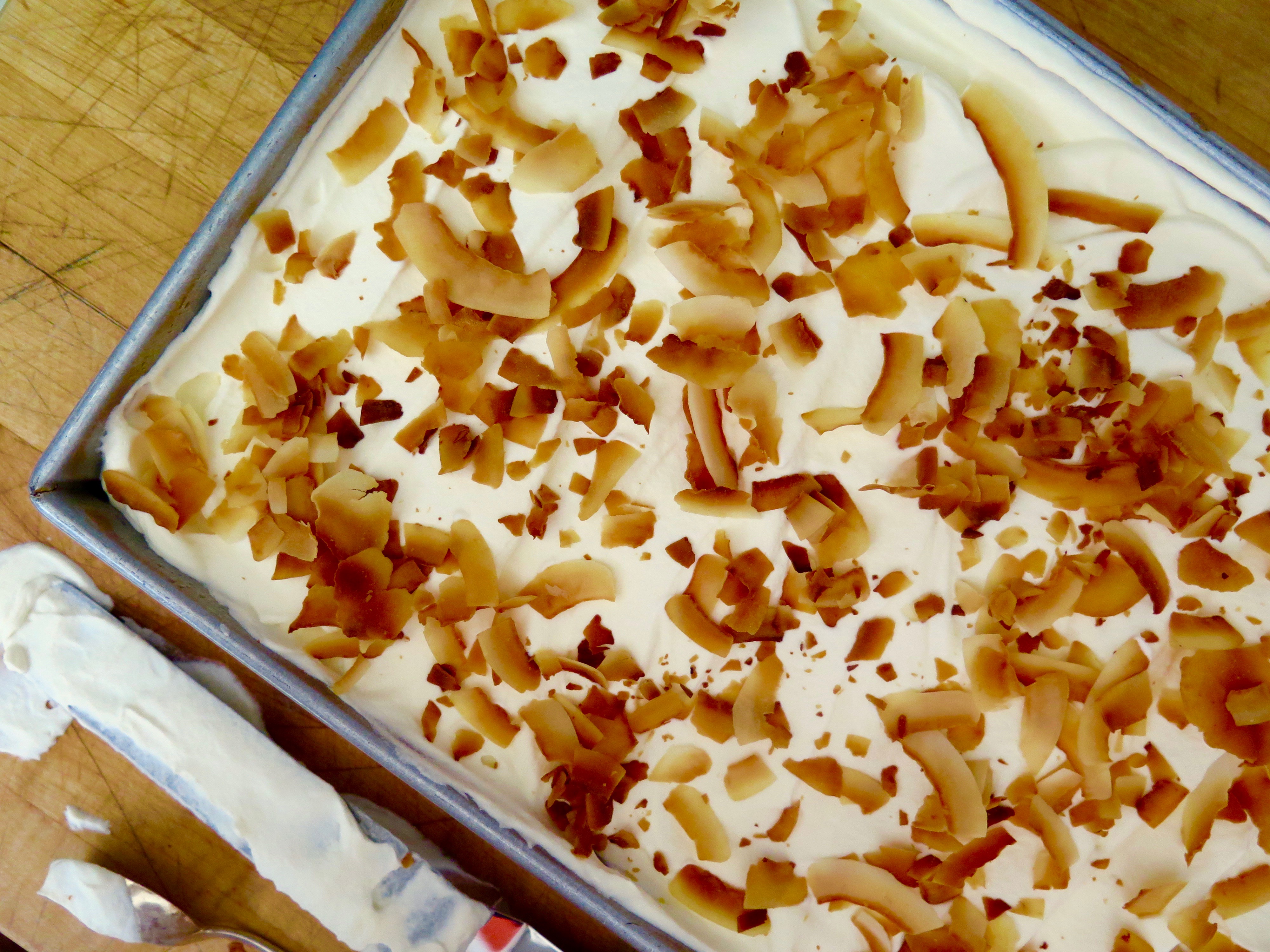 toasted coconut atop a coconut tres leches cake Coconut Tres Leches | Jessie Sheehan Bakes